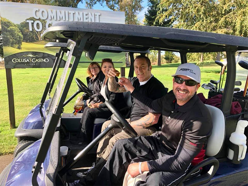 Golfers smiling in a golf cart during an outing at Plumas Lake Golf Club.